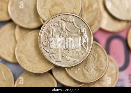 Une pièce australienne d'un dollar untop d'une pile de pièces et de billets de banque. Banque D'Images