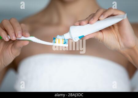 Gros plan vue femme pressent le dentifrice à la brosse à dents du tube Banque D'Images