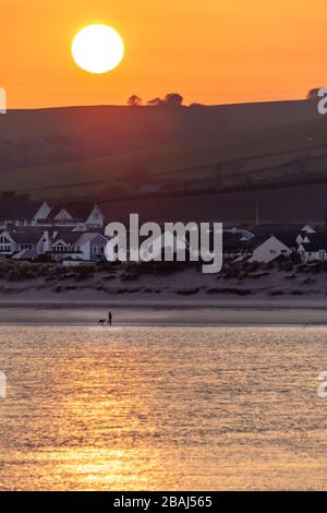 Instow, North Devon, Angleterre. Samedi 28 mars 2020. Un début brillant mais froid à la journée dans North Devon. Contrairement au week-end précédent, au lever du soleil, un marcheur solitaire de chien a la plage à Instow pour lui-même comme une nouvelle directive demandant aux gens de ne pas conduire à exercer leurs chiens est ajoutée aux mesures de distanciation sociale et d'auto-isolement pour limiter la propagation de Covid-19. Crédit: Terry Mathews/Alay Live News Banque D'Images