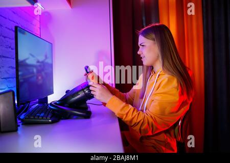 gamer fille jouant à la course sur un ordinateur. Elle utilise un volant. Jeu émotionnel Banque D'Images