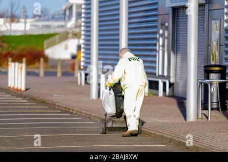 Glasgow, Écosse. 28 mars 2020. Une figure solitaire de collecte d'autres peuples ordures dans un parc de détail déserté Colin Poultney / Alay Live News Banque D'Images