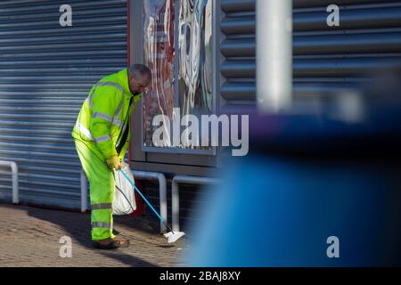 Glasgow, Écosse. 28 mars 2020. Une figure solitaire de collecte d'autres peuples ordures dans un parc de détail déserté Colin Poultney / Alay Live News Banque D'Images