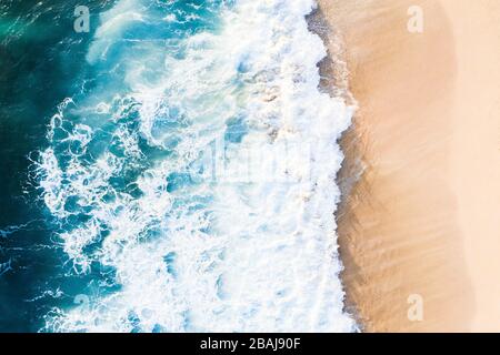 Vue d'en haut, vue imprenable sur les vagues qui s'écrasent sur une belle plage pendant une journée ensoleillée. Plage de Nyang Nyang, Bali Sud, Indonésie Banque D'Images