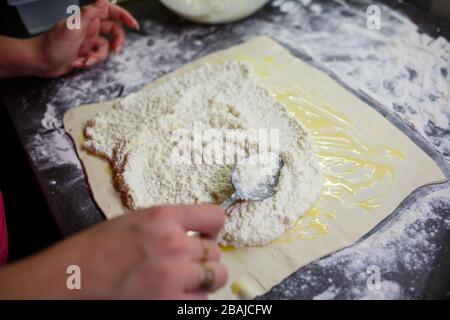 Faire cuire des petits pains avec du fromage. Mettre du fromage sur la pâte pour les petits pains Banque D'Images