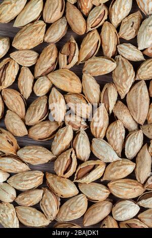 Amandes brutes non pelées dans un sac en textile fait à la main, concept de nourriture biologique et saine. Espace pour le texte, table en bois Banque D'Images