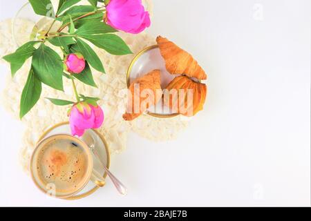 Le petit-déjeuner avec deux tasses de café et croissants, bouquet de fleurs roses pivoines Banque D'Images