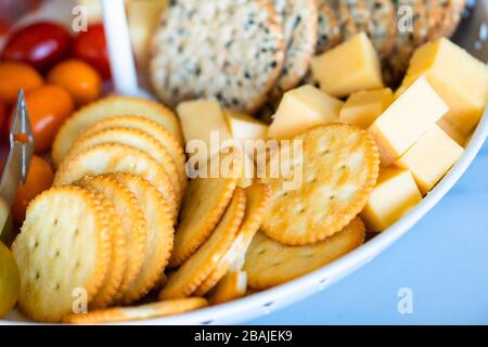 Un plateau rempli de niveaux blanc saumon fumé, fromage, biscuits, fruits et baies. Banque D'Images