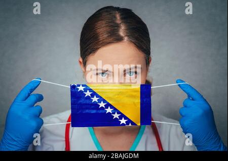 Coronavirus en Bosnie-Herzégovine Portrait de médecin féminin protège le masque médical chirurgical du visage avec le drapeau national de Bosnie-Herzégovine. Illnes Banque D'Images