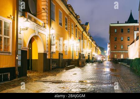 Riga, Lettonie - Juillet 3, 2016 : Façades de vieux célèbre Jacob's Barracks et une partie de l'ancien mur de la ville en haut de l'éclairage dans la rue au soir ou nuit Illu Banque D'Images