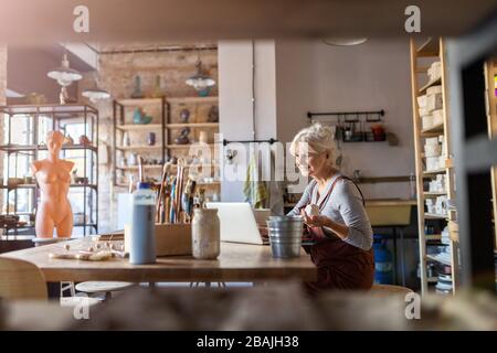 Portrait de la femme senior poterie artiste dans son studio d'art Banque D'Images