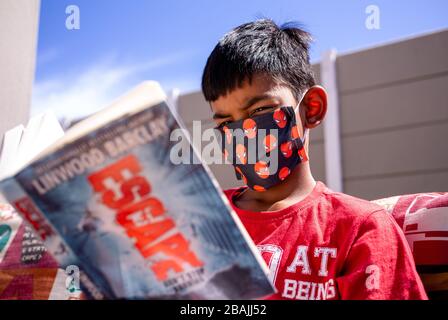 CAPE TOWN, AFRIQUE DU SUD - Samedi 28 Mars 2020: Benjamin (10), un jeune garçon de l'école primaire de Gordons Bay, lit un livre. Banque D'Images