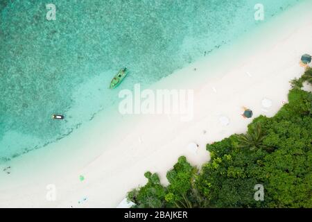 Vue aérienne sur une plage parfaite et un lagon turquoise sur une petite île tropicale aux Maldives Banque D'Images