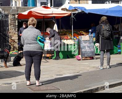 New Mills, Derbyshire. 28 mars. 2020 une file d'attente se forme sur le marché de New Mills, avec un avis de tableau noir remerciant les clients de leur patience. Les règles gouvernementales pendant le balayage du coronavirus dans le pays sont pour les gens de garder deux mètres de distance des autres quand à l'extérieur. La règle de base est que les gens restent à l'intérieur, sauf lorsqu'il est nécessaire de quitter la maison, comme faire des achats pour les essentiels. Banque D'Images