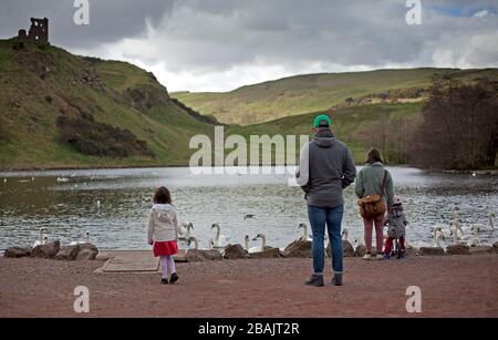 Édimbourg, Écosse, Royaume-Uni. 28 mars 2020. Effet coronavirus, à 11:00 samedi, rues désertes et station-service, cette famille se dirige vers Holyrood Park pour obtenir leur période d'exercice autorisée. Banque D'Images