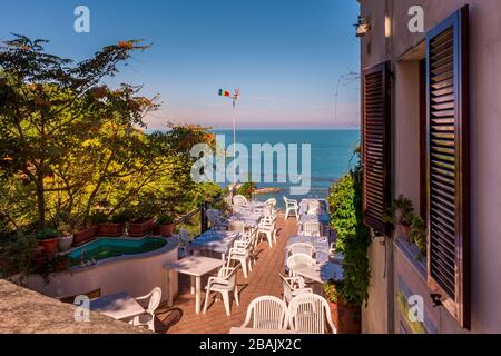 Un restaurant ensoleillé terrasse extérieure donnant sur la mer Adriatique sur la Riviera italienne, Numana, Marche, Italie Banque D'Images