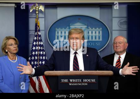 Le président américain Donald J. Trump parle entre le secrétaire américain à l'éducation Betsy DeVos, à gauche, Et Sonny Perdue, Secrétaire à l'agriculture des États-Unis, et Sonny Perdue, Secrétaire à l'agriculture, lors d'un exposé de presse sur la pandémie de Coronavirus COVID-19 avec des membres du Groupe de travail sur le Coronavirus à la Maison Blanche à Washington, DC, le 27 mars 2020. Crédit: Yuri Gripas/Pool via CNP/MediaPunch Banque D'Images