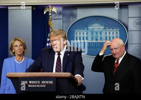 Le président américain Donald J. Trump parle entre le secrétaire américain à l'éducation Betsy DeVos, à gauche, Et Sonny Perdue, Secrétaire à l'agriculture des États-Unis, et Sonny Perdue, Secrétaire à l'agriculture, lors d'un exposé de presse sur la pandémie de Coronavirus COVID-19 avec des membres du Groupe de travail sur le Coronavirus à la Maison Blanche à Washington, DC, le 27 mars 2020. Crédit: Yuri Gripas/Pool via CNP/MediaPunch Banque D'Images