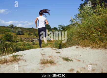 Coureur de fille court le long dans la nature en été. Banque D'Images