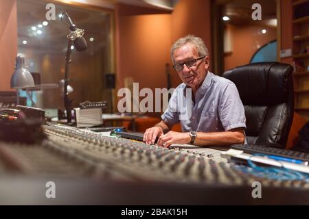 Homme d'âge mûr au bureau de mixage dans un studio d'enregistrement Banque D'Images