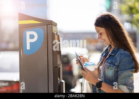 Femme payant pour le parking de la ville Banque D'Images