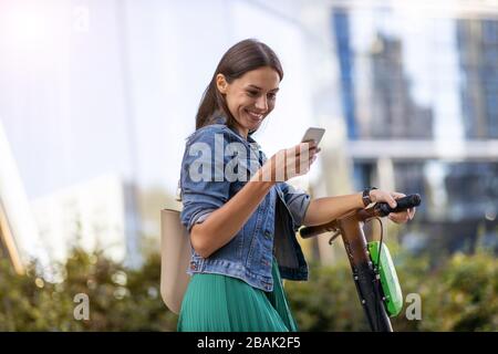 Scooter-poussoir électrique pour déplacement de banlieue femelle Banque D'Images