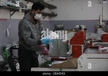 Hébron. 28 mars 2020. Un travailleur palestinien fabrique des sacs en plastique personnalisés pour les hôpitaux afin de jeter les déchets médicaux à l'usine Al-ameer de la ville d'Hébron, en Cisjordanie, le 28 mars 2020. Un fonctionnaire palestinien a annoncé samedi que six nouveaux cas de COVID-19 avaient été enregistrés en Cisjordanie, portant le nombre total de cas dans les territoires palestiniens à 97. Crédit: Mamoun Wazwaz/Xinhua/Alay Live News Banque D'Images