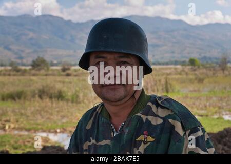 Un chauffeur de moto birman portant un casque de style Wehrmacht populaire au Myanmar Banque D'Images