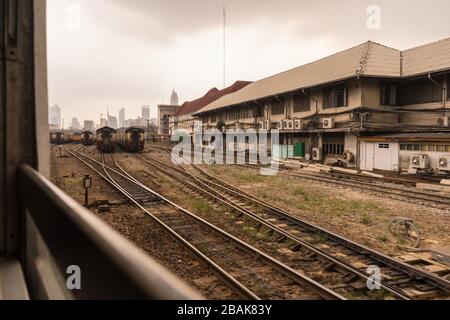 Trains par jour brumeux à la gare centrale. Gratte-ciel dans la distance. Arrivée de l'aéroport international de Don Mueang Banque D'Images