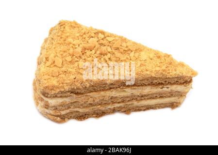 Tranche de gâteau au miel avec crème isolée sur fond blanc Banque D'Images