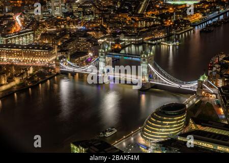 Tower Bridge au-dessus de la Tamise la nuit avec des immeubles de bureaux éclairés, la tour de Londres et menant à Canary Wharf Banque D'Images