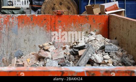 Un dépotoir sale et rouillé de couleur orange plein de déchets de construction comme des carreaux cassés, des ciments, etc des débris. Photographié dans la zone urbaine d'Helsinki. Banque D'Images