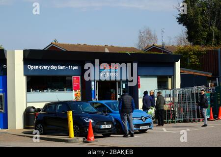 28 mars 2020: Les gens suivant des recommandations de distanciation sociale tout en faisant la queue à l'extérieur du supermarché express Tesco en raison des restrictions imposées par le gouvernement à la circulation pour empêcher la propagation du coronavirus, Southborough, Kent, Angleterre Banque D'Images