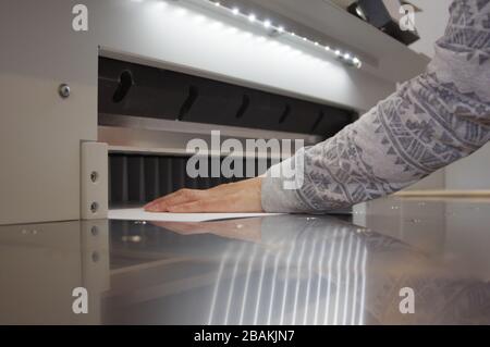 Découpe du papier sur une guillotine. Imprimerie. Fraise pour la découpe du papier. Banque D'Images