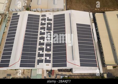 Vue aérienne d'un grand bâtiment moderne à économie d'énergie avec de nombreux panneaux solaires installés sur le toit blanc Banque D'Images