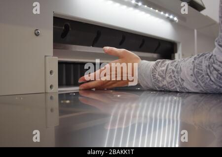 Découpe du papier sur une guillotine. Imprimerie. Fraise pour la découpe du papier. Banque D'Images