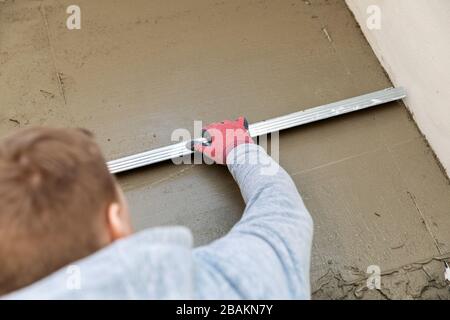 le travailleur de la construction aligne le sol de la table en béton Banque D'Images