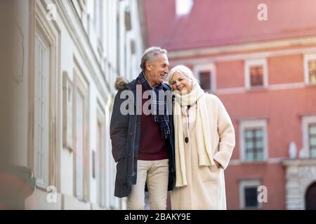 Couple senior marchant dans la rue de la ville le jour de l'hiver Banque D'Images