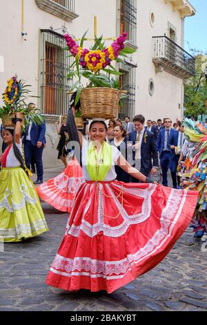 Jeune femme Chino Oaxaqueñas danseuse avec robe rouge et panier de marchandises sur sa tête pendant la parade à Oaxaca, au Mexique Banque D'Images