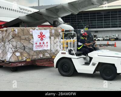 Putrajaya, Malaisie, le 28 mars 2020. (200328) -- SEPANG, 28 mars 2020 (Xinhua) -- un travailleur transporte des matériaux donnés du gouvernement chinois à la Malaisie à l'aéroport international de Kuala Lumpur à Sepang, Selangor, en Malaisie, le 28 mars 2020. La lutte commune contre la COVID-19 a rapproché la Malaisie et la Chine de l'envoi par la Chine de fournitures et de soutien nécessaires à la Malaisie, a déclaré samedi le ministre malaisien des Affaires étrangères, M. Hishammuddin Hussein. (Ambassade de Chine en Malaisie/document d'information via Xinhua) Banque D'Images