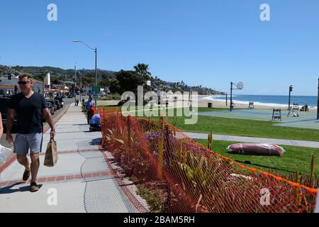 Laguna Beach, CA/USA - 23 mars 2020: Un homme marche en tant que travailleurs clôture au large de Laguna Beach pendant le verrouillage du coronavirus Banque D'Images