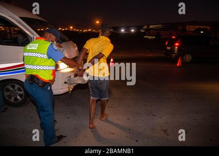 CAPE TOWN, AFRIQUE DU SUD - samedi 28 mars 2020 : Un chauffeur de taxi est arrêté à un barrage à Khayelitsha par des agents de la circulation de la ville du Cap après que le gouvernement sud-africain a déclaré un verrouillage COVID-19 de 21 jours dans le cadre de la déclaration sur l'état de catastrophe nationale du président Cyril Ramaphosa. Le ministère de la Santé a demandé aux résidents d'observer les règlements, de pratiquer l'hygiène, de rester à la maison et de pratiquer la distanciation sociale. Photo de Roger Sedres Banque D'Images