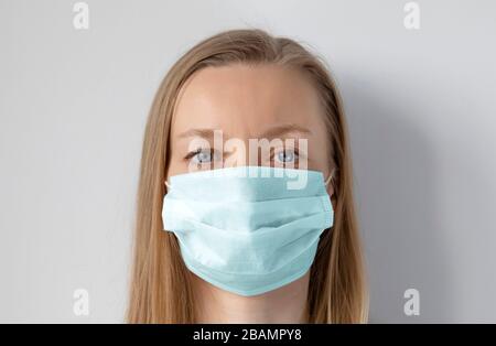 Femme à cheveux légers portant un masque médical pour la protection contre les virus Banque D'Images