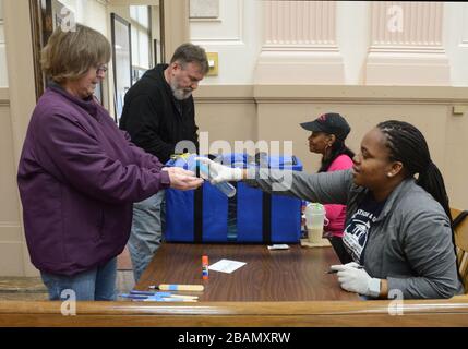 Racine, Wisconsin, États-Unis. 28 mars 2020. Un électeur reçoit un désinfectant pour les mains DE JAMIE KIRKWOOD après avoir voté en tant qu'hôtel de ville de racine est ouvert pour un vote par anticipation, y compris le vote au volant, avant l'élection présidentielle principale et publique prévue pour le 7 avril. Le maire Cory Mason de racine a appelé Gov. Tony Evers reportera les élections à cause de Coronavirus. Un juge fédéral a décidé vendredi de rejeter un procès intenté par la ville de Green Bay qui a tenté de retarder l'élection du Wisconsin en raison de l'éclosion de coronavirus dans le Wisconsin. Crédit: Mark Hertzberg/ZUMA Wire/Alay Live News Banque D'Images