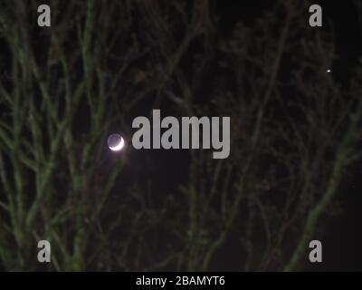 Sheerness, Kent, Royaume-Uni. 28 mars 2020. La lune à côté de Vénus dans le ciel clair de nuit au-dessus de Sheerness, Kent. Crédit: James Bell/Alay Live News Banque D'Images