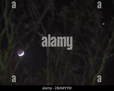 Sheerness, Kent, Royaume-Uni. 28 mars 2020. La lune à côté de Vénus dans le ciel clair de nuit au-dessus de Sheerness, Kent. Crédit: James Bell/Alay Live News Banque D'Images