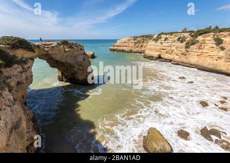 Personne debout sur l'arche de mer sur la côte ouest d'Alporchinhas, Algarve, Portugal Banque D'Images