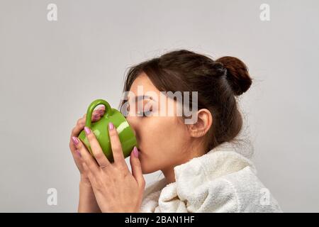 Jeune femme ayant froid et boire du thé chaud. Banque D'Images