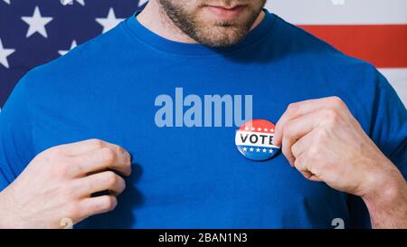 Homme mettant sur le bouton de vote pour l'élection présidentielle 2020 en Amérique. Banque D'Images