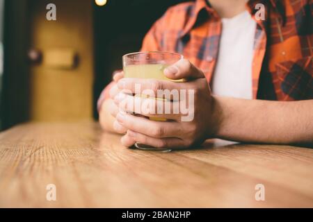 Les jeunes étudiants sont assis au restaurant et goûtent à une boisson chaude. L'homme boit du thé au café Banque D'Images