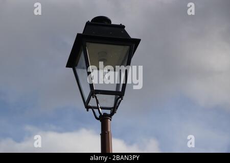 Un panneau sur un poteau à côté d'un poteau de lampe Banque D'Images